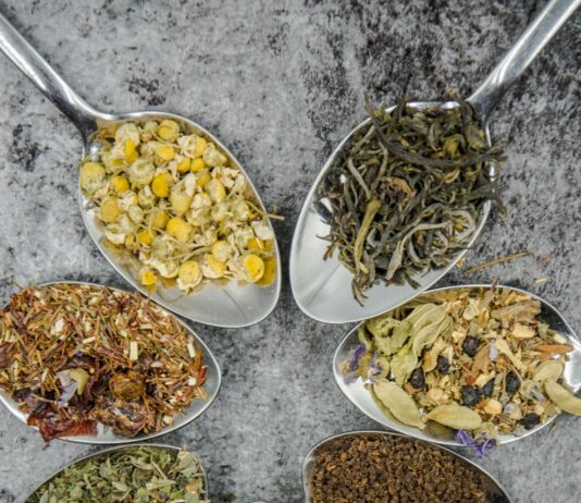 소화불량 해결을 위한 자연 요법 seven different spices and herbs on gray stainless steel spoons