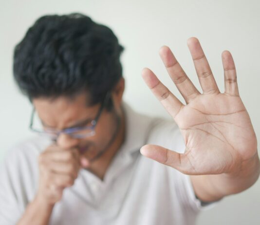 독감 시즌에 알아두면 좋은 증상별 대처법 a man holding his hand up in front of his face