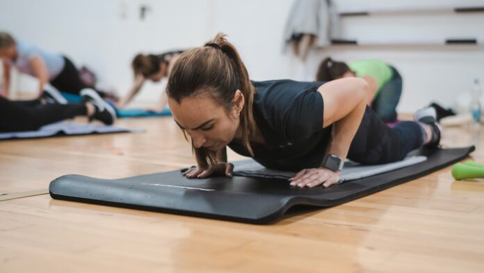 A group of people in a gym doing push ups