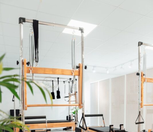 필라테스: 몸과 마음을 강화하는 최고의 운동법 a room filled with lots of machines and a plant