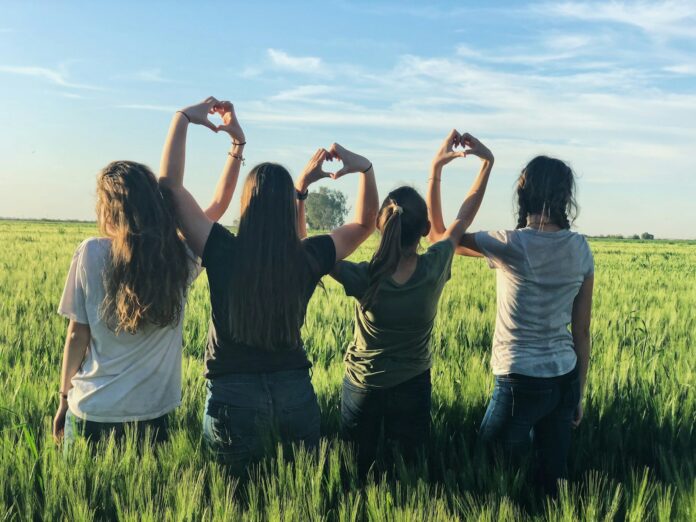 Photo by Melissa Askew women forming heart gestures during daytime