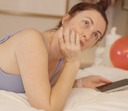 디지털 기기와의 관계 재설정: ‘스크린 디톡스’의 심리·신체 영향 Woman lying on bed with phone and balloons