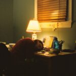 만성피로, 작은 습관 바꾸기로 일상 활력 되찾기 a person sitting at a desk in front of a lamp