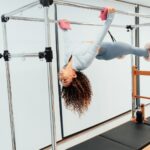 갓생의 완성: 매일 아침 몸을 깨우는 ‘골든 타임’ 10분 루틴 a woman doing a handstand on a parallel bar