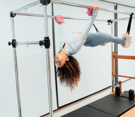 갓생의 완성: 매일 아침 몸을 깨우는 ‘골든 타임’ 10분 루틴 a woman doing a handstand on a parallel bar