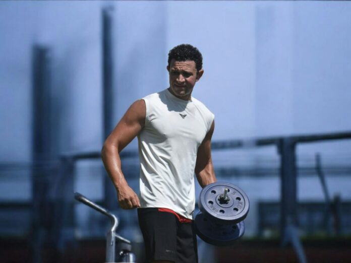 Photo by Ramy Mamdouh Man lifting weights at an outdoor gym.