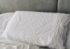 꿀잠을 위한 새로운 루틴, 수면 건강 트렌드와 실천법 A rumpled white duvet and pillows on a bed.