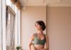 몸도 마음도 가볍게, 집에서 즐기는 필라테스 라이프 a woman in a green sports bra top and leggings holding a yoga mat
