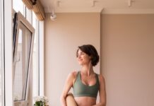 몸도 마음도 가볍게, 집에서 즐기는 필라테스 라이프 a woman in a green sports bra top and leggings holding a yoga mat