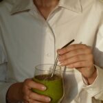 나를 돌보는 일상, 확산되는 ‘웰니스’ 문화…실천 가능한 건강 루틴은? person in white button up shirt holding clear drinking glass with green liquid