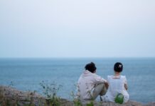 정신건강, 일상 속 작은 변화를 통한 회복의 시작 two people sitting on a rock looking out at the ocean